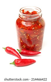 Fresh red chilly and bottled chili sauce over white background