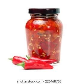 Fresh red chilly and bottled chili sauce over white background