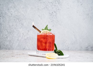 Fresh Red Cocktail In An Old Fashion Glass With A Burning Cinnamon Stick