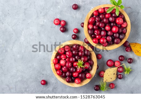 Fresh red cranberry in wooden bowl. Autumn harvest of wild berries. Above view.