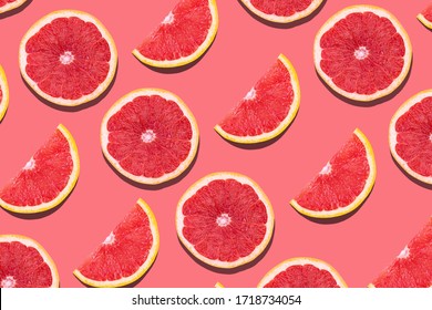 Fresh red orange or grapefruit on a peach color background. Beautiful cut juicy slices. Pattern seamless tropical fruit photo.