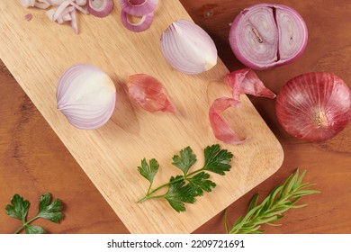 Fresh Red Whole And Sliced Onion. Sliced Red Onion With Parsley And Rosemary . Onion And Slices On Wooden Cutting Board. Freshly Picked From Home Growth Organic Garden. Food Concept.