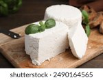 Fresh ricotta (cream cheese) and basil on table, closeup