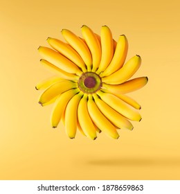 Fresh ripe baby bananas falling in the air isolated on yellow background. Food levitation concept. High resolution image - Powered by Shutterstock