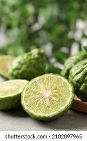 Fresh ripe bergamot fruits on light grey table against blurred background, closeup. Space for text