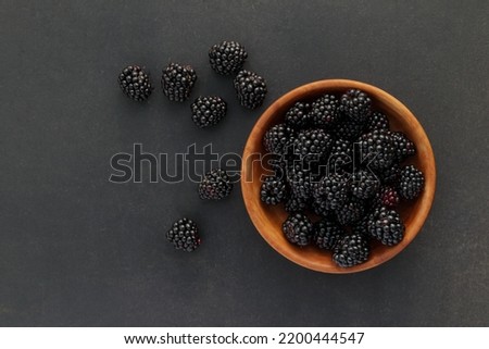 Fresh ripe blackberry in brown wooden bowl