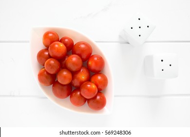 Fresh Ripe Cherry Tomatoes On Small Plate, Photographed Overhead On White Wood With Natural Light 