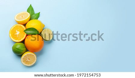 Fresh ripe citrus fruits on blue background. Orange, lemon, lime. Top view flat lay with copy space