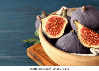 Fresh ripe figs in a wooden bowl on a blue background - Powered by Shutterstock