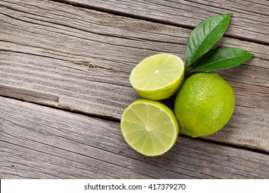 Fresh ripe limes on wooden table. Top view with copy space