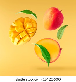 Fresh ripe mango with leaves falling in the air isolated on yellow background. Food levitation concept. High resolution image - Shutterstock ID 1841206000