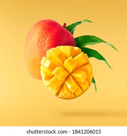 Fresh ripe mango with leaves falling in the air isolated on yellow background. Food levitation concept. High resolution image - Shutterstock ID 1841206015