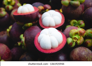 Fresh ripe mangosteen fruits and cross section showing the thick purple skin and white flesh. - Image