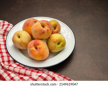 Fresh ripe peaches fruit on a white dish and cloth over the vintage background. Top view. Close-up photo. ealthy food and fruit concept