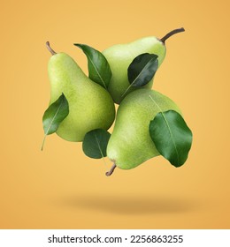 Fresh ripe pears and green leaves falling on orange background - Shutterstock ID 2256863255
