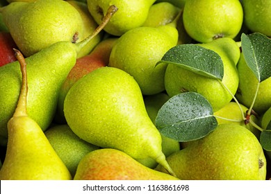 Fresh ripe pears with leaves as background