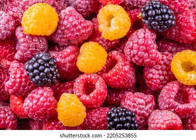 Fresh ripe, red and yellow, raspberries and blackberries background pattern close-up.