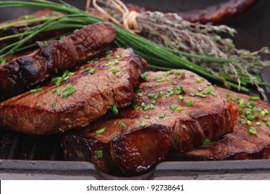 fresh ripe roasted beef meat on barbecue pan with thyme and pepper isolated on white background