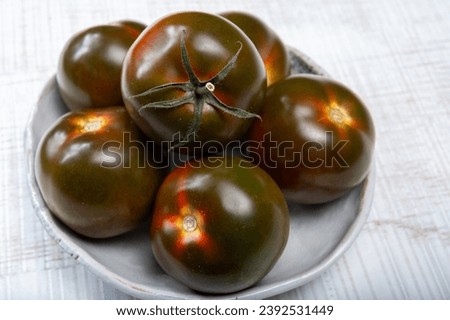 Fresh ripe sweet reddish brown and green kumato tomatoes close up