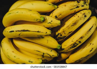Fresh ripe yellow bananas in wicker basket on wooden background