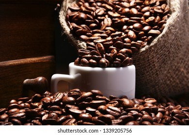 Fresh roasted coffee beans in burlap sack, coffee cup and grinder on dark background. - Shutterstock ID 1339205756