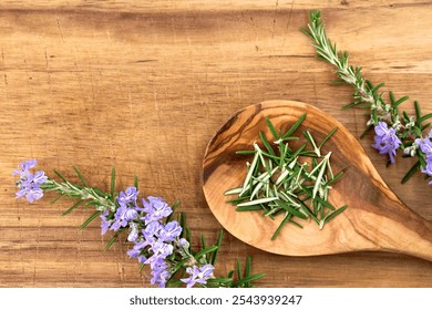 Fresh rosemary needles in a wooden spoon next to blooming rosemary branches on a wooden cutting board, use of rosemary as a herb or for aroma therapy - Powered by Shutterstock