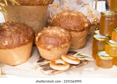 Fresh Round Bread With A Golden Crust Close-up On A Wooden Board. The Concept Of Food Stability.