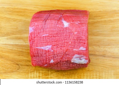 Fresh Round Steak, Beef Steak From The Eye Of Round, Rear Leg Meat Of Cow Without Round Bone, Femur. Top View On Wooden Background
