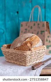 Fresh rustic bread in a wicker basket on table.
