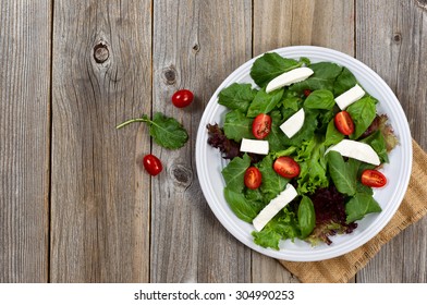 Fresh Salad With Cheese, Cherry Tomato, Basil, Baby Kale, And Lettuce On Rustic Wood. 