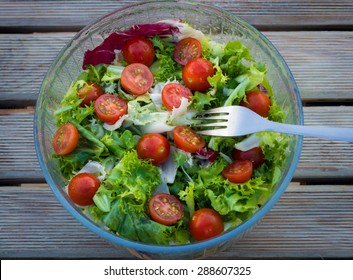 Fresh salad of cherry tomatoes and lettuce on a wooden background - Powered by Shutterstock