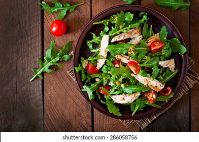 Fresh salad with chicken breast, arugula and tomato. Top view