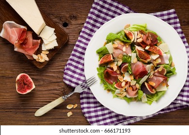 Fresh salad with figs and prosciutto with parmesan cheese and toasted almonds. Top view. - Powered by Shutterstock