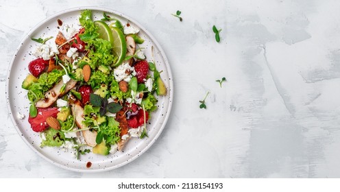 Fresh salad fruit strawberry with chicken meat avocado, feta cheese, lettuce and nuts balsamic vinegar, Balanced food. Delicious detox diet. Top view.