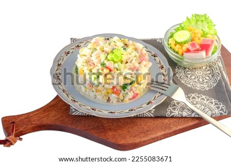 Fresh salad on a blue plate of crab sticks, sweet corn, cheese, fresh cucumber, boiled egg with dill and mayonnaise.