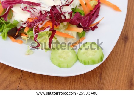 Fresh salad on a plate on brown background