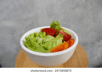 Fresh salad on the table served in the white bowl