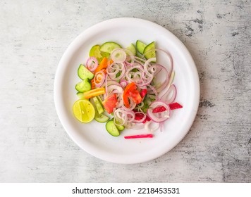 Fresh salad with onion, cucumber, carrot, lemon and tomato served in a plate isolated on background top view of indian and pakistani desi food