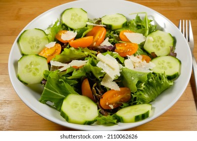 Fresh Salad With Parmasan Cheese Shavings On Bed Of Spring Mix Lettuce With Cucumber And Yellow Tomatoes