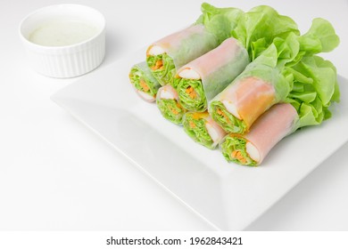 Fresh Salad Spring Roll There Are Many Kinds Of Vegetable, Lettuce, Carrot, Onion, And Crab Stick On White Dish With Sauce In White Mini Bowl Isolated On White Background. Close Up Photo.