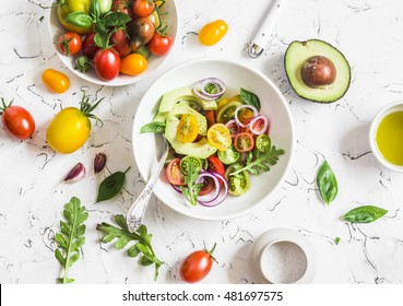 Fresh salad with tomatoes and avocado on a light background. Top view  