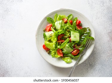 Fresh Salad With Tomatoes, Cucumbers, Capers And Mixed Salad Leaves. Flat Lay