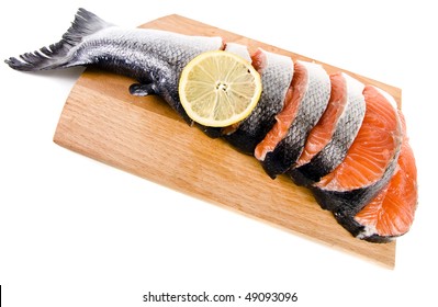 fresh salmon on a cutting wood kitchen board surface isolated on white background