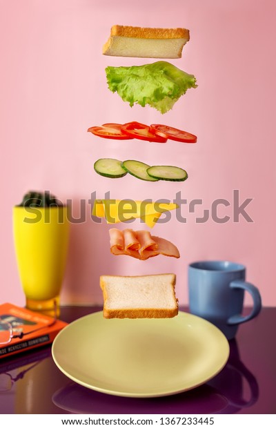 Fresh sandwich with flying ingredients\
isolated on pink\
background.