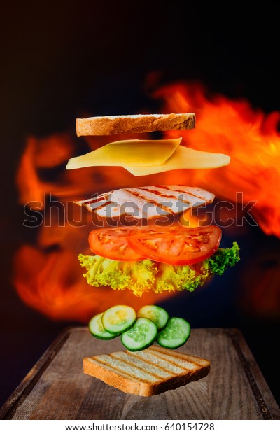 Fresh sandwich\
with flying ingredients isolated on black background. Copyspace for\
text, high resolution\
image.