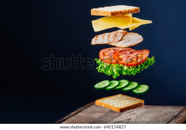 Fresh sandwich\
with flying ingredients isolated on black background. Copyspace for\
text, high resolution\
image.