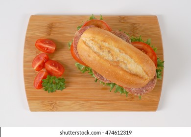 Fresh Sandwich With Salami On Wooden Cutting Board