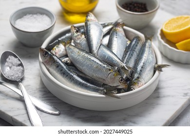 Fresh sardines, lemon and salt on kitchen, close up shot