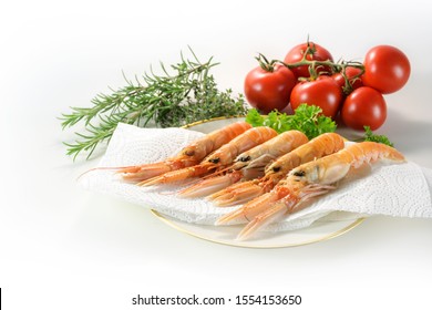 Fresh Scampi, Also Called Norway Lobster Or Langoustine, On A Plate With Paper Towel, Herbs And Tomatoes, Ready To Cook An Expensive Seafood Meal, White Background With Copy Space, Selected Focus