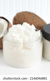 A Lot Of Fresh Scrub In Jar With Coconut On White Background. Home Spa Treatment Concept, Organic Cosmetic. Vertical Photo. 